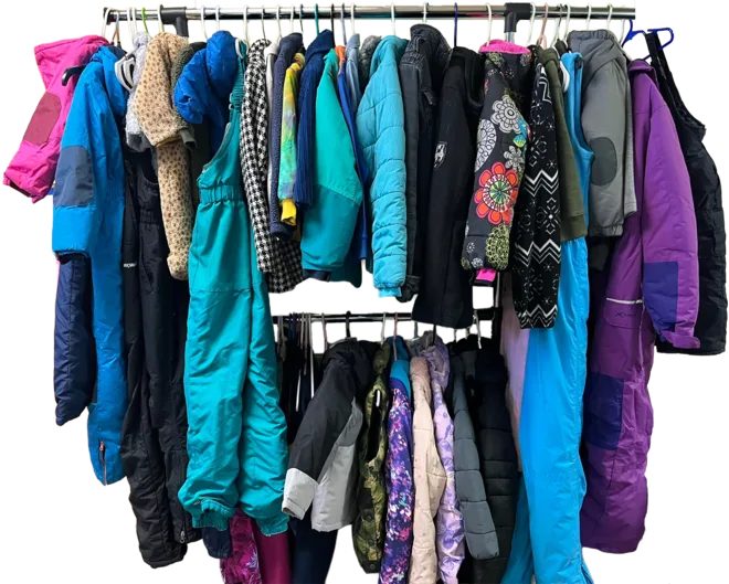 A rack packed two deep with winter coats and snow pants